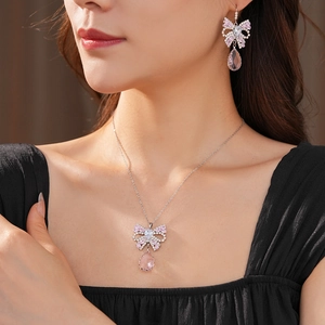 Close-up of pink bow jewelry set with teardrop tassels on model in French vintage style