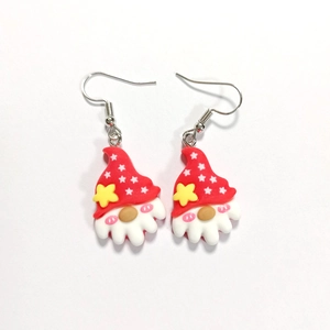 Detail view of cartoon Christmas gnome earrings with red hats and festive resin charms