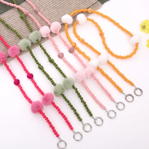 Plush beaded mobile phone crossbody straps with faux fur balls and heart charms in multiple colors