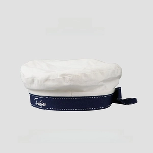 Detail of white sailor beret with navy ribbon, embroidery and bow decoration