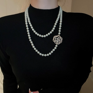 Vue détaillée d'un collier de perles double épaisseur avec pendentif rose sur un mannequin