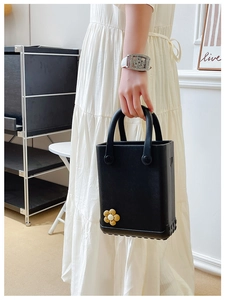 Detailansicht der schwarzen EVA-Strandtasche mit rutschfestem Boden und süßem Blumenanhänger