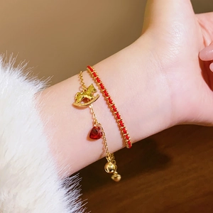 Détail d'un bracelet poney plaqué or 18k et d'une corde rouge sur une manche blanche