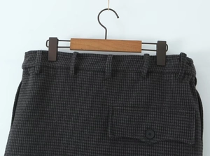 Detailed macro view of the houndstooth pattern fabric with buttoned pocket on the skirt