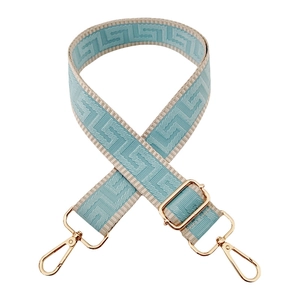 Detail of 3.8cm light blue and beige woven strap with geometric Greek key pattern and gold hooks