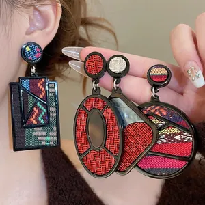Ethnic geometric drop earrings with black frames and colorful woven fabric inlays