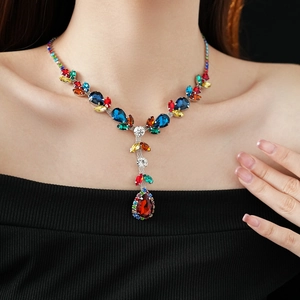 Detail of vintage necklace featuring multi-color stones and a red teardrop pendant
