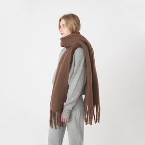 Thick brown mohair scarf with tassels shown on a model against a white background