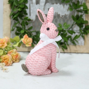Detailed close-up of pink woven texture resin bunny with a white silk bow decoration