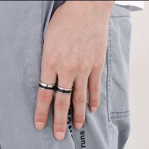 Close-up of dual-tone titanium rings with Roman numerals worn for a stylish look