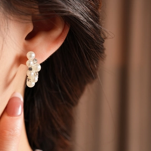Vista macro de elegantes pendientes de plata con perlas y cristales de estilo retro