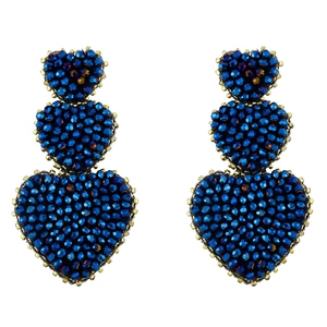Close-up of triple heart drop earrings featuring navy blue beads and gold metal edges