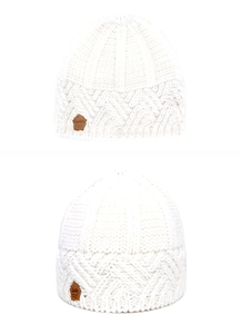 Detail of white chunky knit beanie with diamond pattern and side leather logo patch