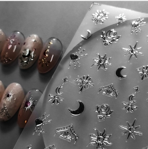 Macro detail of silver celestial nail stickers with moon, sun and star foil designs