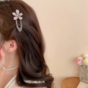 Detail view of pink acrylic flower hair clip with rhinestones worn on hair