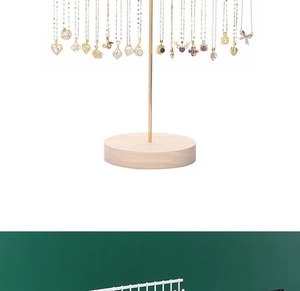 Detail view of gold necklaces with assorted pendants on a metal stand with wooden base