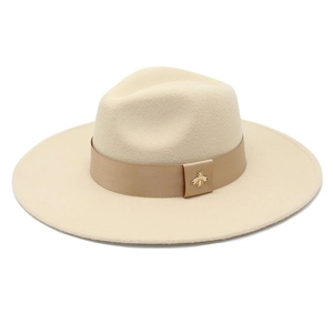 Detail of cream wool fedora featuring a camel ribbed ribbon and golden bee ornament