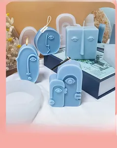 Detailed view of abstract face silicone molds and blue art candles for DIY home decor