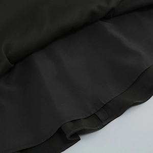 Detail des schwarzen Kleidsaums mit hochwertigem Webstoff und feiner Nahtverarbeitung