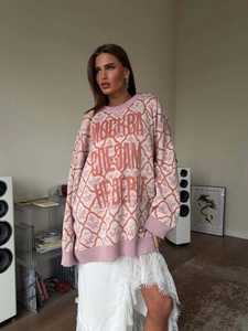 Oversized pink and cream argyle knit sweater with drop shoulders and red graphic text
