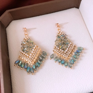 Detail of tassel earrings with crystals and pearls in a brown jewelry box