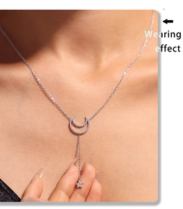 Wearing effect of a layered silver necklace with zircon moon and star tassel charms