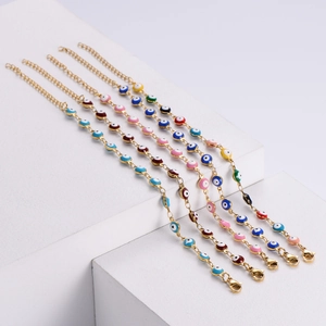 Detailed set of five gold-plated evil eye bracelets in various colors on minimalist display
