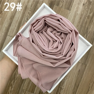 Détail du hijab en mousseline rose poudré avec paillettes argentées sur un plateau