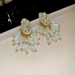 Detailed macro view of pearl drop earrings with sparkling zircon inlay in a jewelry box