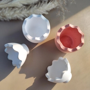 Close-up of petal-edged eggshell resin molds in white and pink for DIY storage bowls