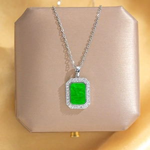 Detail of emerald green rectangular pendant with silver sparkling crystal border