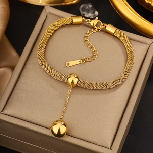 Detailed view of gold mesh woven bracelet featuring a hanging polished bead charm