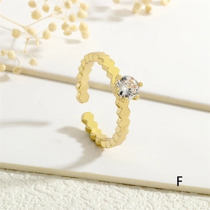 Detail macro shot of a gold wavy band ring with a round zircon stone and open design