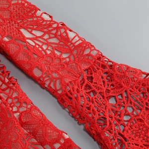 Détail de dentelle florale rouge vif avec une doublure en mesh couleur chair douce