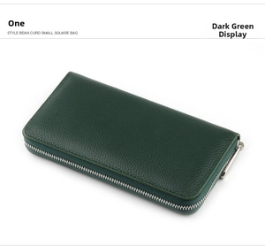 Detail of dark green pebble grain leather long wallet with silver zipper closure