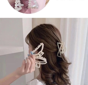 Macro detail of cream pearl bow hair claw clip showing elegant textured pearl arrangement