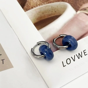 Detailed shot of 18k gold plated stainless steel hoops with blue marble stone charms