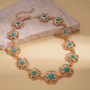 Detail of gold flower chain necklace with turquoise cabochon and crystal accents