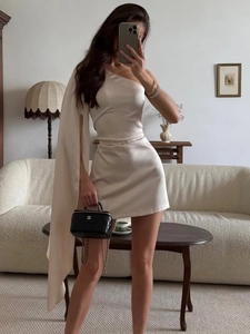 Elegant beige one-shoulder satin mini dress with a draped cape sleeve and slim fit design