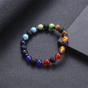 Macro shot of 8mm lava rock chakra bracelet with colorful natural stones on dark base