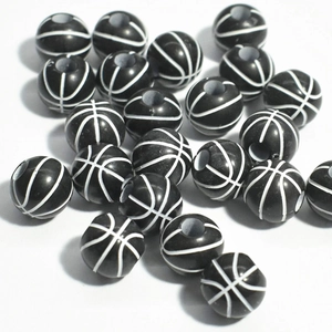 Macro shot of 50 black and white basketball-shaped acrylic spacer beads for DIY jewelry