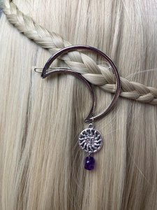 Detail view of silver crescent moon hair clip with purple crystal on braided hair