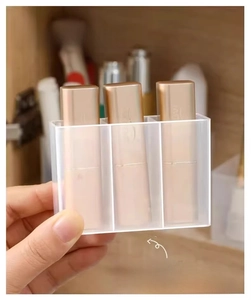 Macro detail of a transparent three-slot acrylic wall organizer for lipsticks and samples