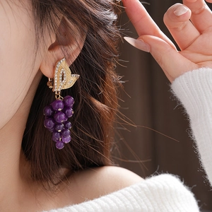 Detail of vintage French purple bead grape earrings with gold leaves on model
