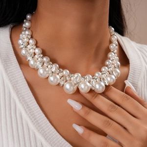 Detail showing elegant white faux pearl choker necklace with sparkling crystal accents