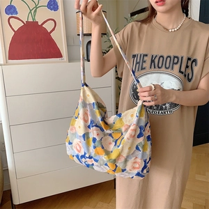 Artistic floral canvas tote bag with large capacity shown in a daily lifestyle setting
