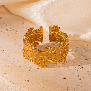 Detailed close-up of an 18K gold-plated palm ring with embossed patterns on silk