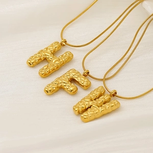 Gold snake chain necklaces with H, F, and W alphabet pendants featuring textured designs