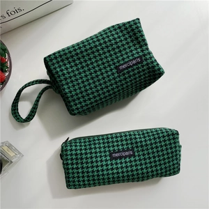 Detail of green houndstooth pouch set with wristlet and merciparis woven label
