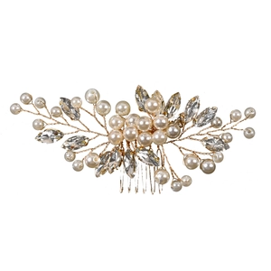 Detailed close-up of golden wire bridal hair comb with pearls and rhinestone crystals